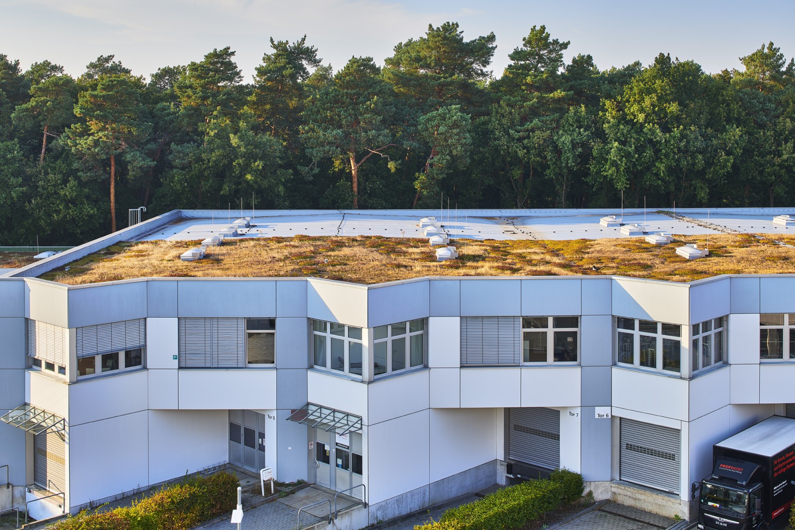 Blick auf ein Gebäude mit Lieferzugängen, gelegen am Rande eines Waldes auf dem Europarc Dreilinden.